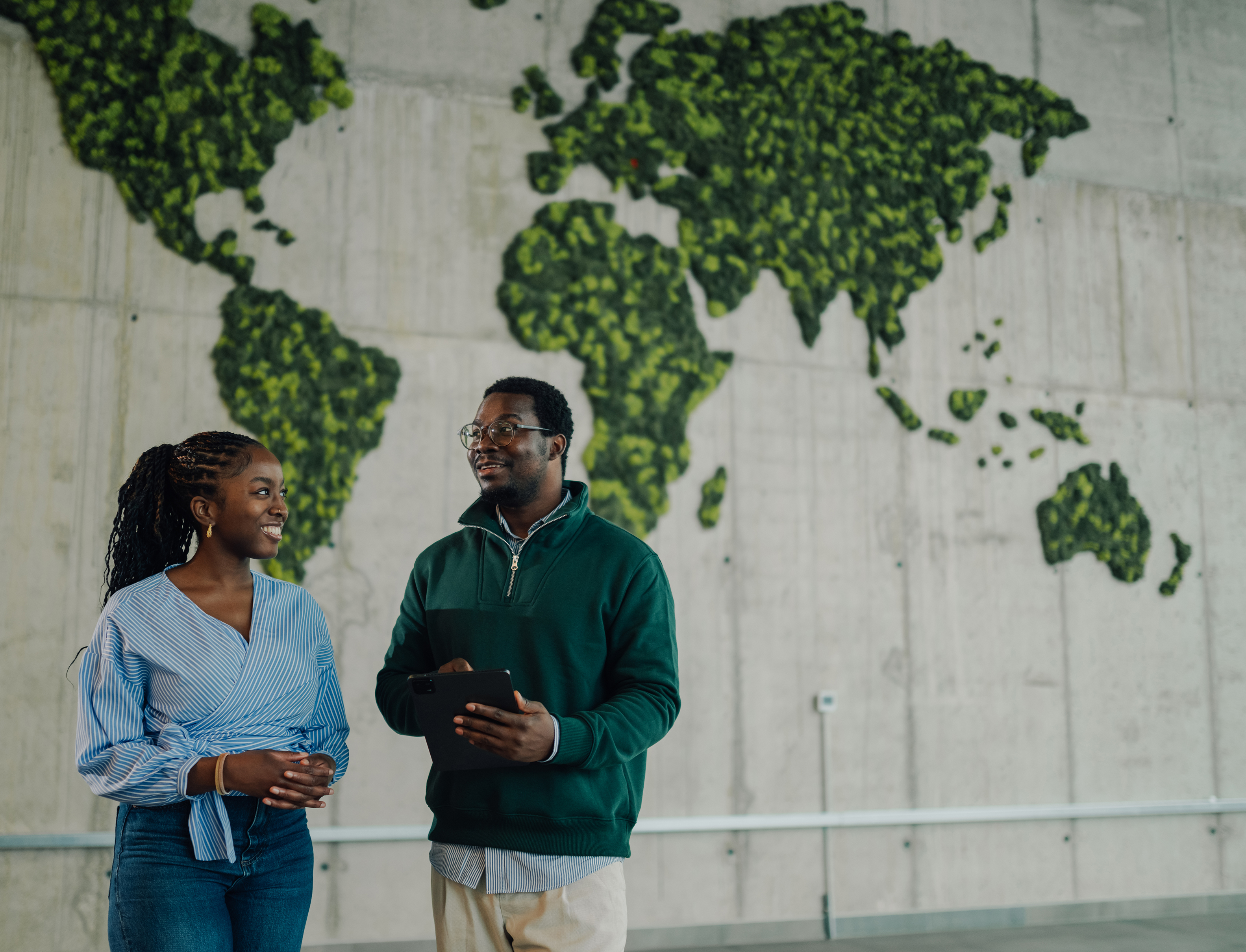 Colleagues in front of a green world map